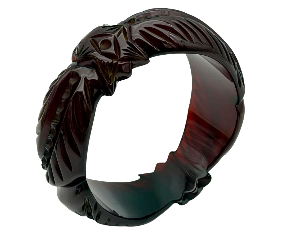 Carved Prystal Catalin (Bakelite) Bangle Bracelet – Translucent Oxblood, 1930s: A finely carved vintage Catalin (phenolic resin, commonly referred to as Bakelite) bangle bracelet dating to the 1930s, executed in a desirable translucent “prystal” form. The bracelet display