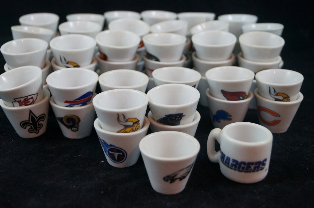 LOT OF 63 Mini Sports Mini Shot Glasses Memorabilia: LOT OF 63 Mini Sports Mini Shot Glasses Memorabilia. Huge variety of mainly football teams including Raiders, Cowboys, Lions and more. Each glass has the team logo on front. About 1 1/2" inches tall. 