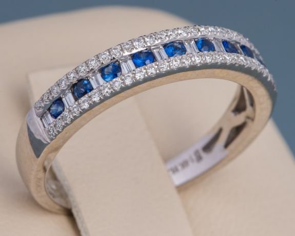 14K WHITE GOLD SAPPHIRE AND DIAMOND BAND: 14K WHITE GOLD SAPPHIRE AND DIAMOND BAND 3.8mm, 14K white gold band with nine, round, blue sapphires totaling .14 carat. Surrounding the sapphires are round and baguette diamonds, totaling .25 carat. 