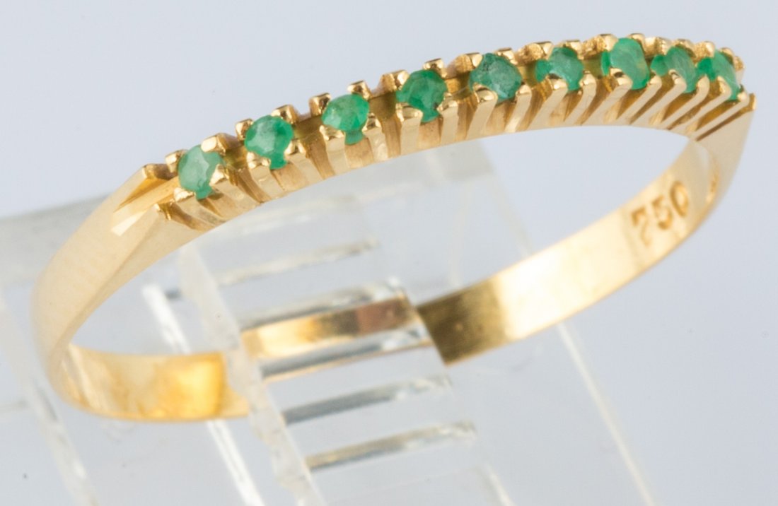 18K YELLOW GOLD OVAL EMERALD & DIAMOND RING: 18K YELLOW GOLD OVAL EMERALD & DIAMOND RING Ladies' 18k yellow gold band with nine cool green emeralds totaling .04ct. Weight: 0.7g Size: 6