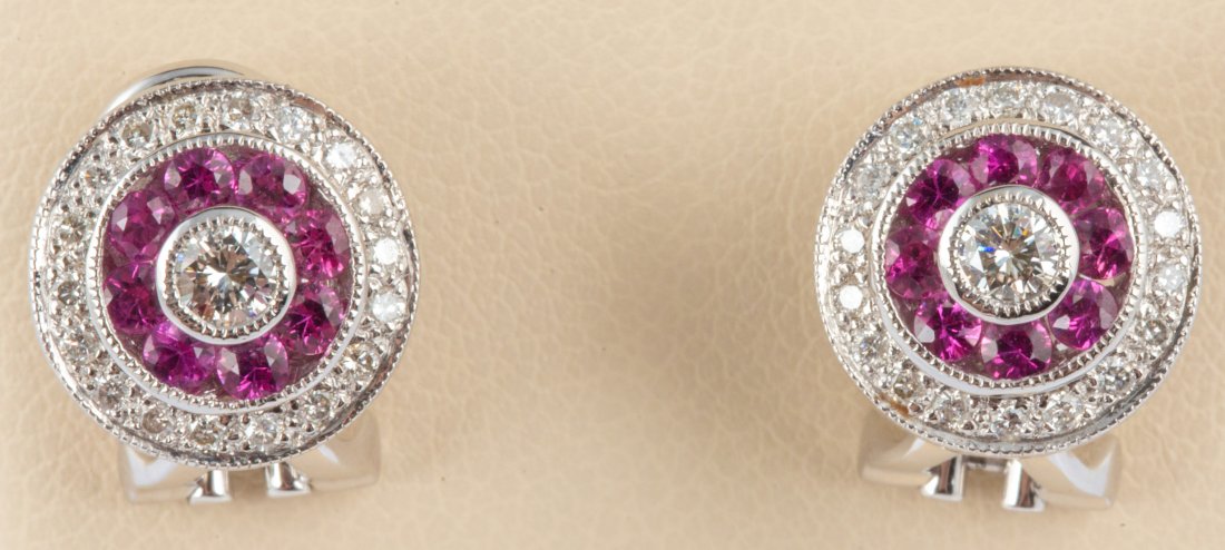 18K WHITE GOLD RUBY AND DIAMOND EARRINGS: 18K WHITE GOLD RUBY AND DIAMOND EARRINGS Ladies’ 18k round French clip pierced earrings with 8 round intense red Burmese rubies, .04 ct each, .60 ct total. Rubies surrounded by 20 round diamonds. Ru
