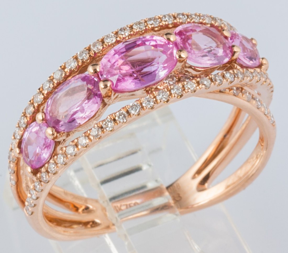 18K ROSE GOLD PINK SAPPHIRE & DIAMOND FASHION BAND: 18K ROSE GOLD PINK SAPPHIRE & DIAMOND FASHION BAND Cross over design fashion band produced in 18k rose gold. 1.8ctw in 5 oval cut pink sapphires dive over the band, graced by .29ctw in accent diamonds