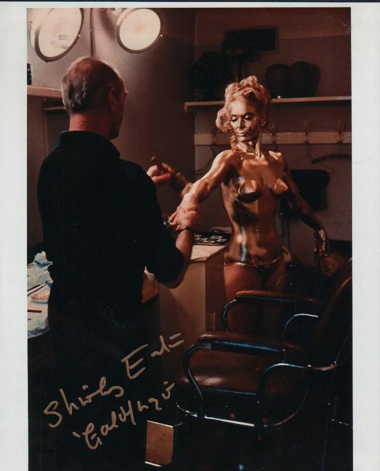 Shirley Eaton signed James Bond photograph: A rare behind the scenes signed 8x10 of her being painted gold for the film Goldfinger which she adds in addition to signing in what else ! Gold ink ! With COA