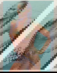 Ursula Andress signed photograph: In wet SEE THRU dress signed by the first James Bond babe from Dr No ! This item comes with a fully illustrated serial numbered letter of authenticity guaranteeing its authenticity for the life of