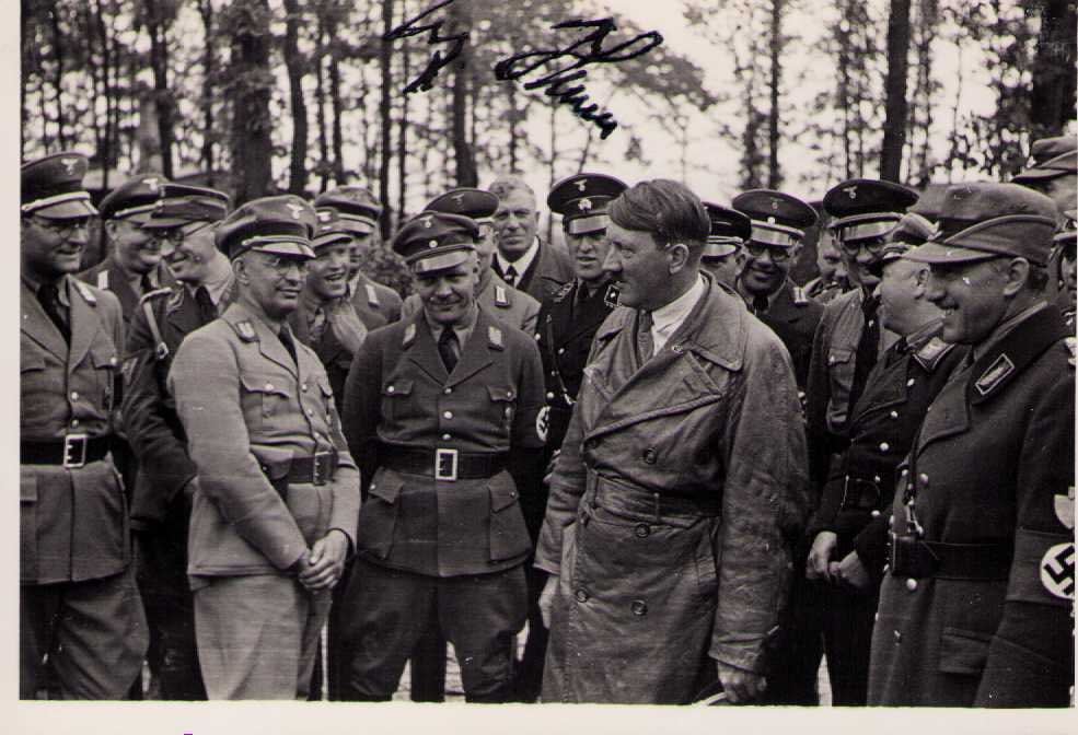 Adolph Hitler signed photograph: A rare real photograph with photographers back stamp of him with the troops in WWII it was signed for a troop member who was there by the Fuhrer in black fountain pen ink Certificate of AuthenticityEV