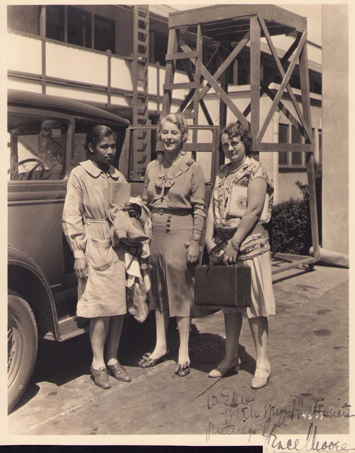 Grace Moore signed photograph: A behind the scenes shot on the lot at MGM showing Grace an unidentified woman likely an assistant and hairdresser Edith Hubner holding a breifcase signed to edie with my affectionate greetings its ir