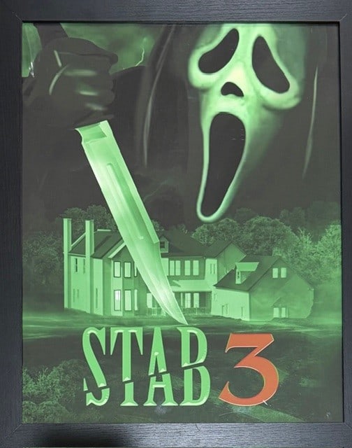 Scream 7 framed art seen on screen in macher house: A framed STAB poster seen on screen and used in the film Scream 7 acquired from an auction of set pieces for cast and crew at the films finish Certificate of AuthenticityEVERY item in this auction