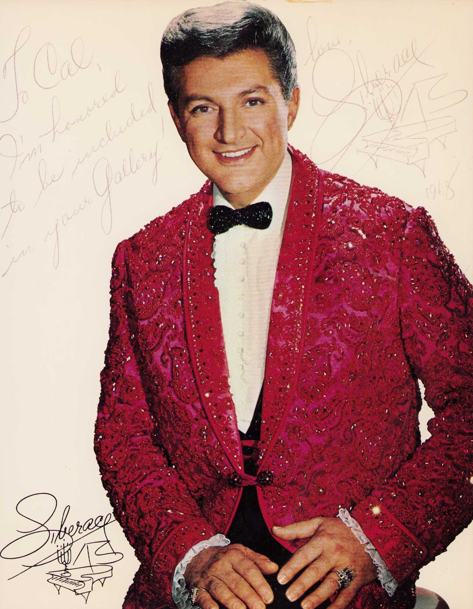Liberace signed photograph: A wonderful 8x10 signed by the legend plus he has sketched a piano with candelabra Certificate of AuthenticityEVERY item in this auction comes with at minimum one fully illustrated and serial numbered
