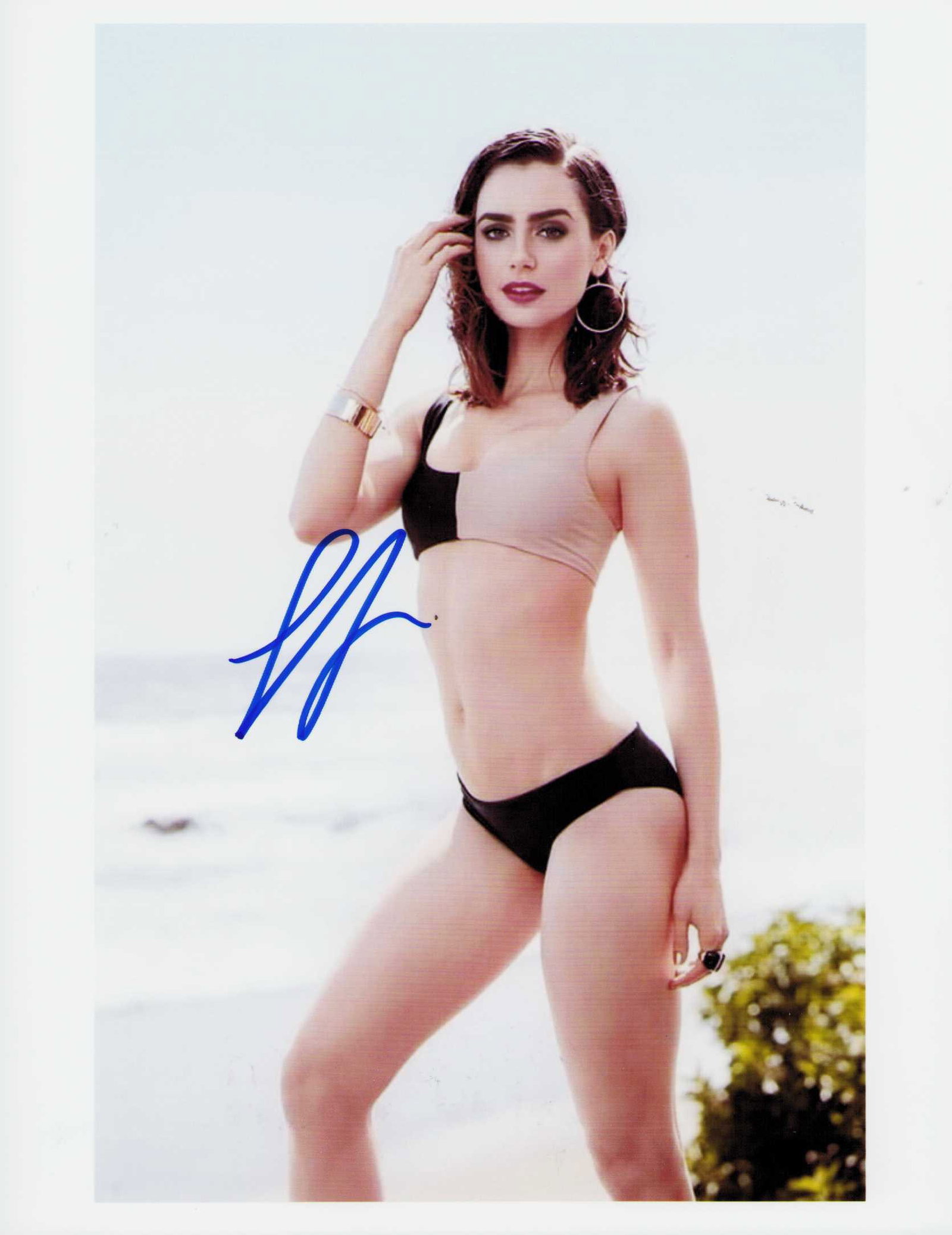 Lily Collins sexy signed photograph: A sexy signed 8x10 by Phil Collins daughter the actress on Emily in Paris currently Certificate of AuthenticityEVERY item in this auction comes with at minimum one fully illustrated and serial numbere