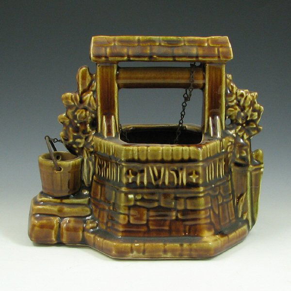 McCoy #725 Wishing Well Planter: McCoy #725 wishing well planter in brown and green with chain. Marked McCoy USA. Minor chips. 7" tall by 8 1/2" long.