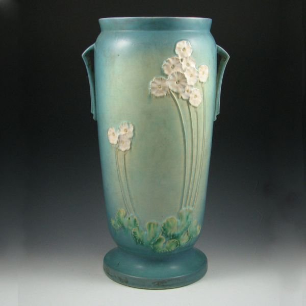 Roseville Primrose #773 Umbrella Stand: Roseville Primrose umbrella stand in blue. Marked Roseville 773. There are four chips to the piece, a broad bruise to the rim and a 7" hairline crack descending from the rim. 20 3/4" tall.Provenance: 