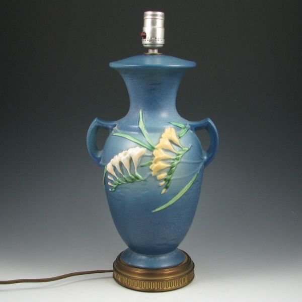 Roseville Freesia Factory Original Lamp: Roseville Freesia factory original lamp in blue. Marked 23 in crayon on the base. There is a minute glaze nick to the rim. Pottery portion is 13" tall with an overall height of 17".Provenance: Collect