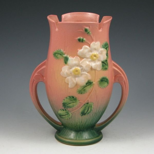 Roseville White Rose 986-9" Vase - Mint: Roseville White Rose handled vase in pink and green. Marked Roseville USA 986-9". Mint with factory glaze peppering around the rim. 9 1/4" tall by 7 1/4" wide.
