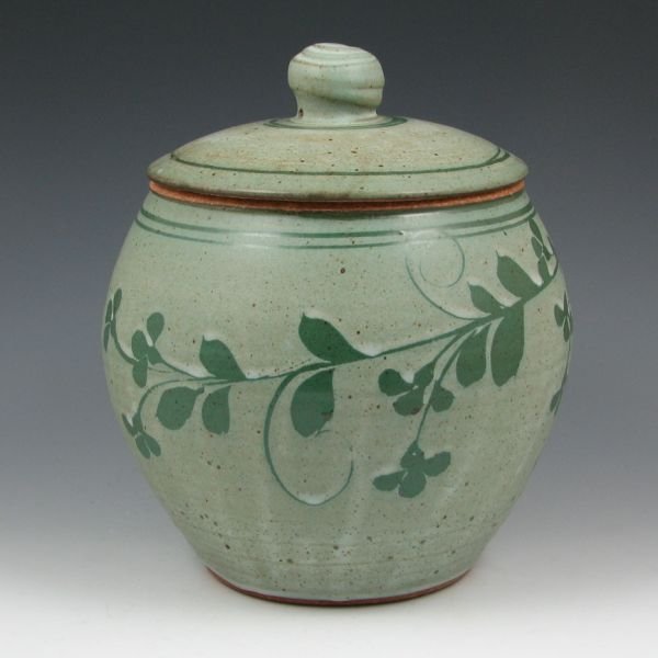 Alan Patrick 9 1/4" Lidded Vessel - Mint: Alan Patrick lidded vessel with dark green floral decoration on a light green body. Marked with impressed stamps for Alan Patrick (AP) and The Bethel Pottery. Mint. 9 1/4" tall.