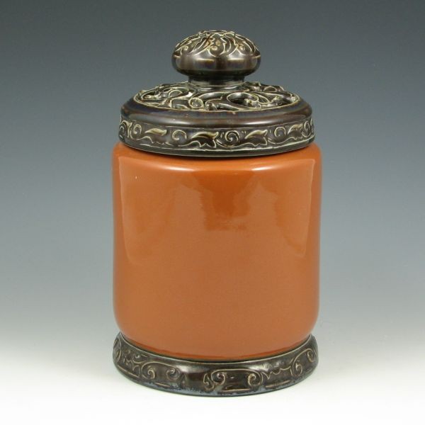 Rookwood 1924 Lidded Humidor: Rookwood humidor from 1924 with attached base and lid made to appear to be carved teak. Marked with Rookwood logo, XXIV and the shape number 2622. The jar body is mint. The lid has been dropped, broke