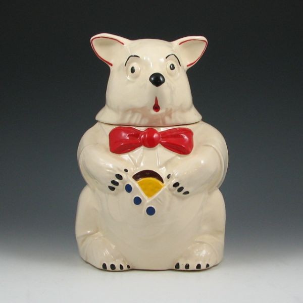 McCoy Bear w/ Cookie In Vest (White) Cookie Jar: McCoy bear with cookie in vest cookie jar in white. Marked McCoy. Some roughness to the inner rim of the base. 10 1/2" tall.