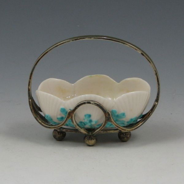 Belleek Shell Salt In Sterling Basket - 1st Black: Belleek Shell salt in a sterling silver basket. Marked with black 1st Mark (1863-1890). Two hairlines to the rim of the piece. Pottery measures 3 1/8" by 1 1/8" while the basket is 2 7/8" tall.