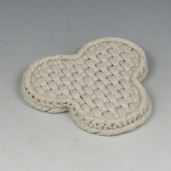 Belleek Three-Strand Basket Base (1865-1889): Belleek three-strand basket base. This piece is the base or foot of a basket that has been made to act as a stand or trivet. To clarify, this is a post-production creation, likely made to salvage part