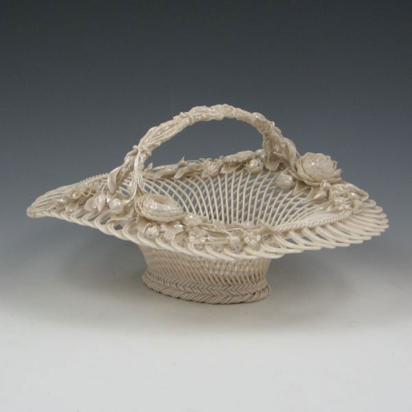 Belleek Three-Strand Floral Basket (1890-1920): Belleek three-strand oval basket with arch handle and Mother of Pearl finished decoration. Marked Belleek Co. Fermanagh on a single pad (circa 1890-1920). Some loss to the applied decoration with one