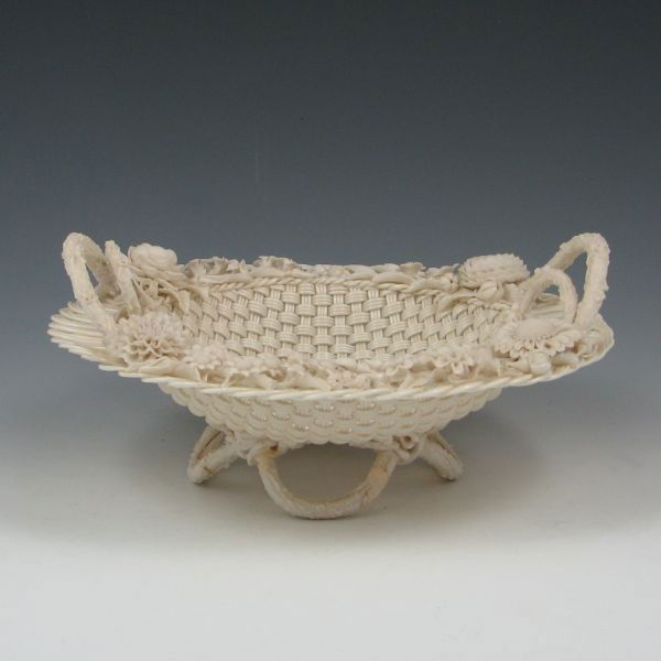 Belleek Three-Strand Footed Basket (1890-1920): Belleek three-strand basket with parian (bisque) finished flowers and handles. Marked Belleek Co. Fermanagh on a single pad (circa 1890-1920). Minor loss to the applied decoration. Two of the loop fee