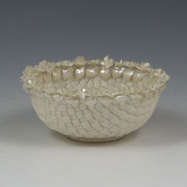 Belleek Bird's Nest Basket (1921-1954): Belleek Bird's Nest basket with applied flowers and leaves in Mother Of Pearl lustre. Marked Belleek, Co. Fermanagh and Ireland on three separate pads (1921-1954). Mint. 4" wide by 1 3/4" tall.