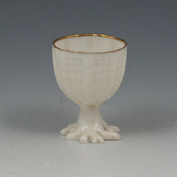 Belleek Tridacna Egg Cup: Belleek Tridacna egg cup. Gold rim. Unmarked. Small chip to edge of base. 2 1/4" tall.