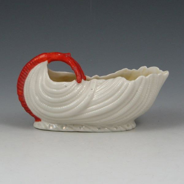 Parian China Creamer w/ Orange Handle: Parian China creamer with orange handle and yellow lustre interior. Unmarked. Two flakes to rim. 6 1/8" long by 3 1/8" tall.
