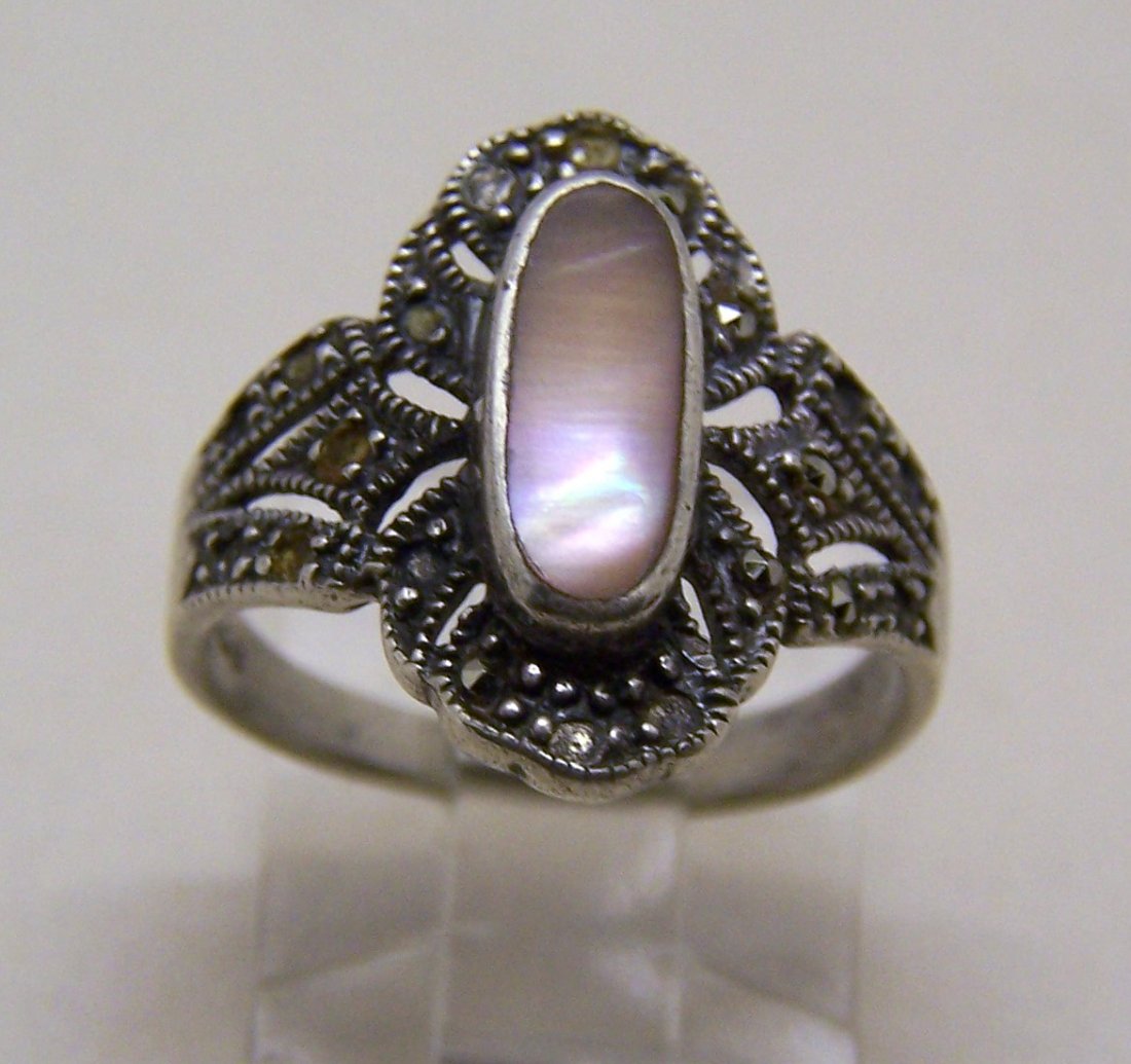 vintage sterling silver marcasite mother of pearl ring: top of the ring measures 6/8" long by 6/8" wide, size 6, weights 3.4 grams, marked 925 CW, in good condition, missing some of the marcasite.