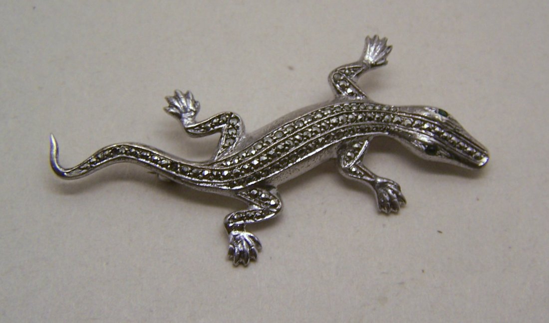 crocodile sterling silver marcasite brooch pin: measures 2 2/8" long by 15/16" wide, crafted with marcasite & 2 green glass eyes, 1 of the eyes have an invisible chip, crafted 7.3 grams, marked sterling in good condition missing 2 marcasite.