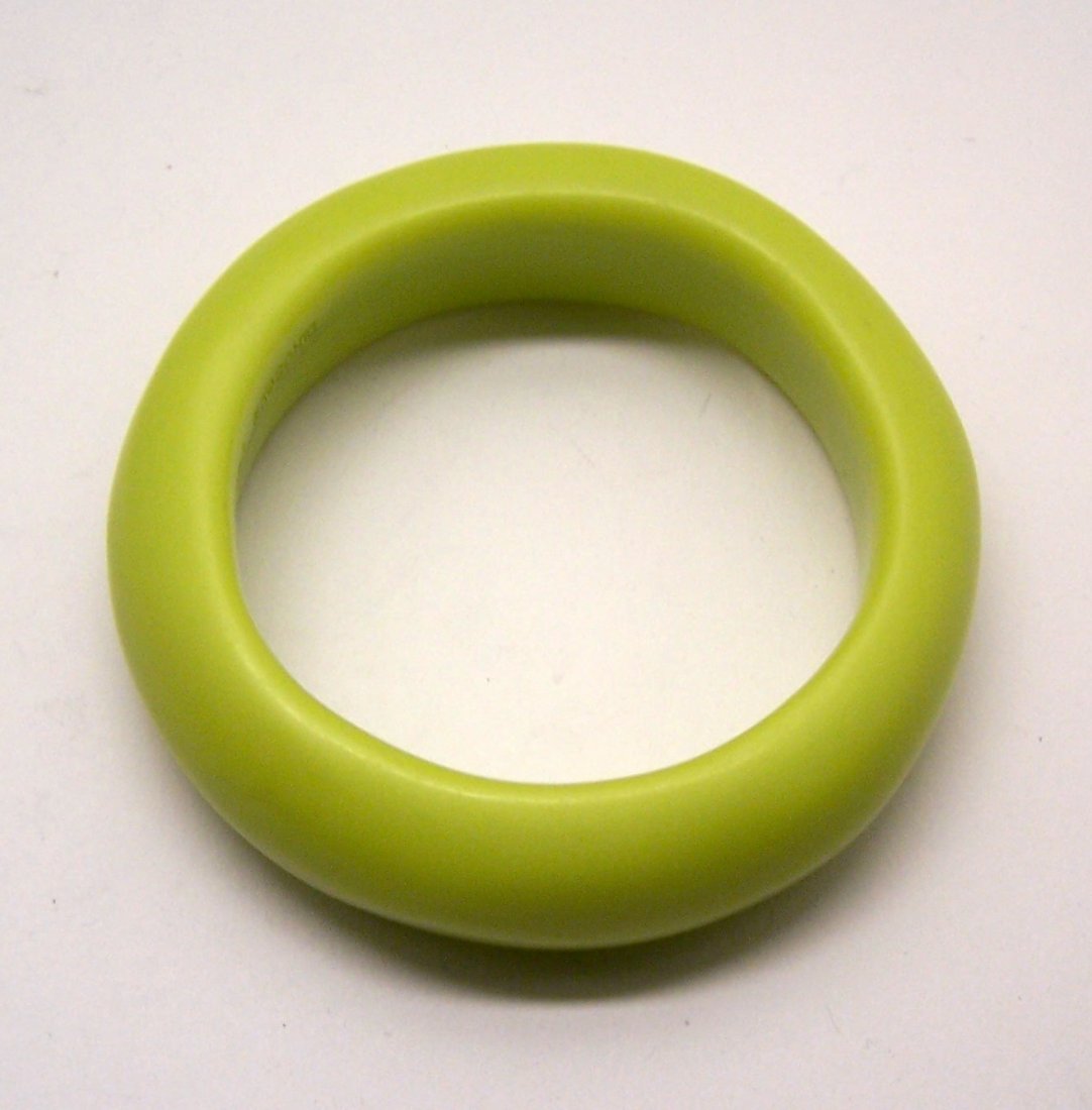 DINOSAUR DESIGNS carved lucite bangle bracelet: measures 8 1/4" inside circumference by 1" wide, weights 79.6 grams, in great condition, the color is more like Bitter Lemon.