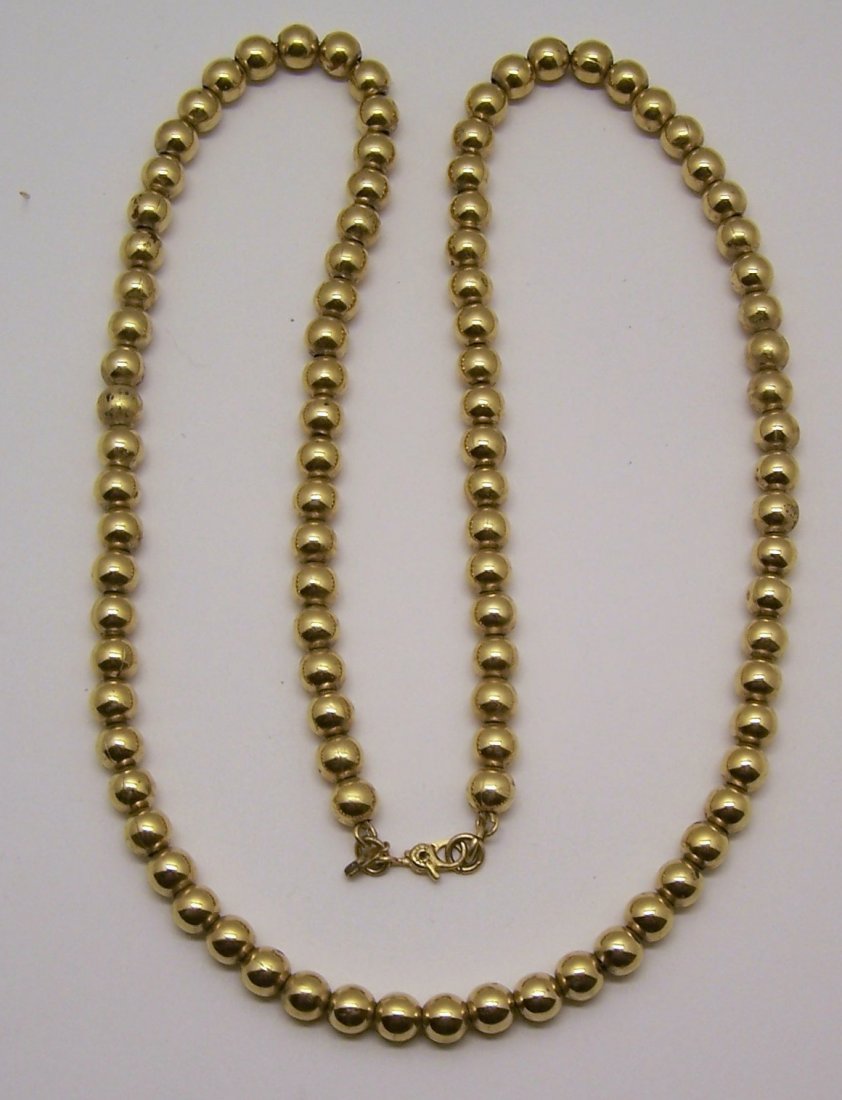 vintage monet gold tone bead necklace: measures 24 3/8" long crafted with 6mm gold tone beads, weights 54 grams, signed monet, in great condition.