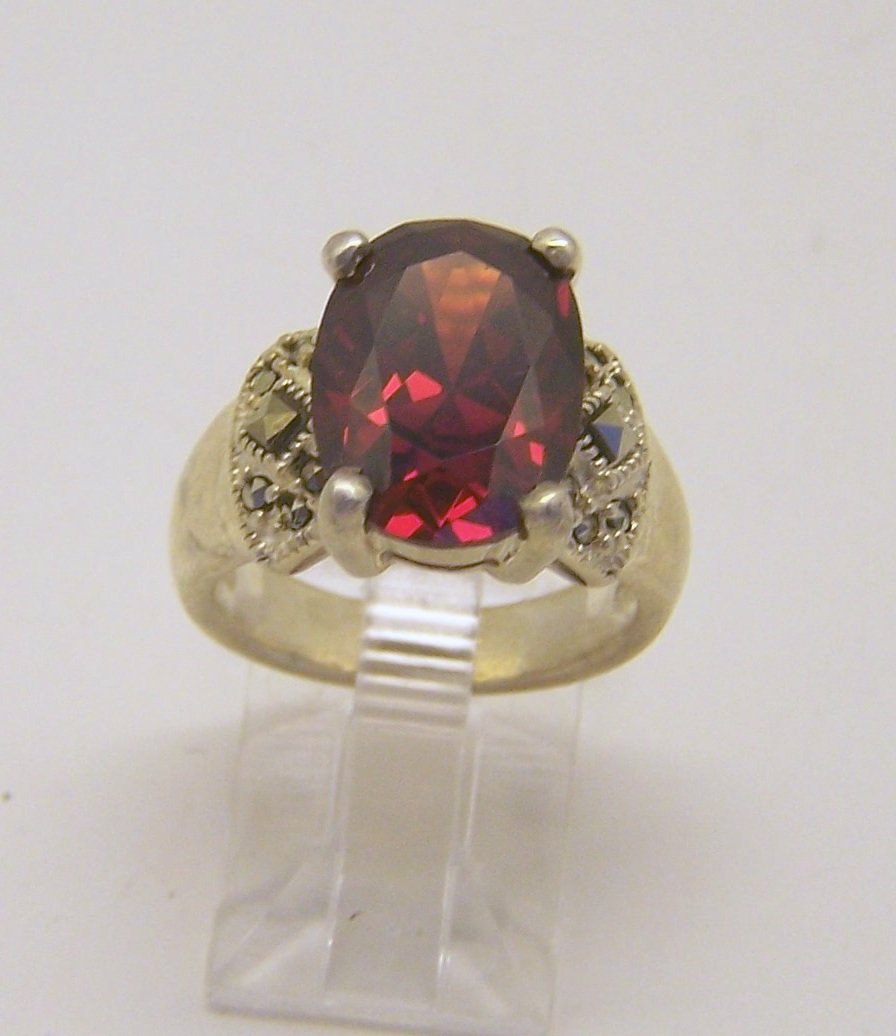 sterling silver garnet marcasite ring: top of the ring measures 9/16" wide, crafted with 14x10mm garnet, size 6, weights 8.1 grams, in good condition