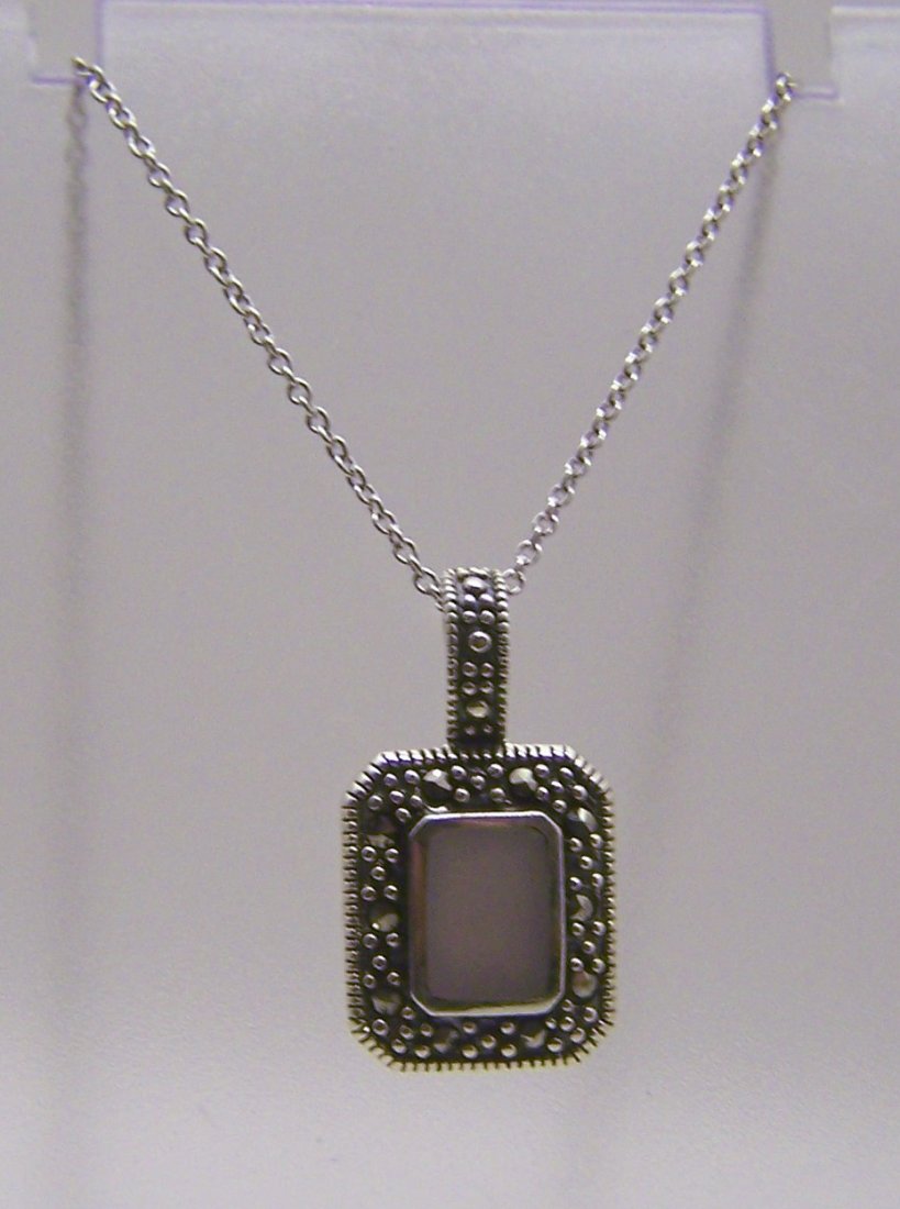 A sterling silver mother pearl marcasite necklace: chain measures 18 1/8" long, pendant measures 15/16" long, weights 4.2 grams, in good condition
