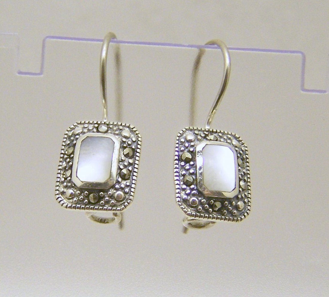 A sterling silver marcasite mother pearl earrings: measures 1" long by 7/16" wide, weights 3.7 grams, in good condition