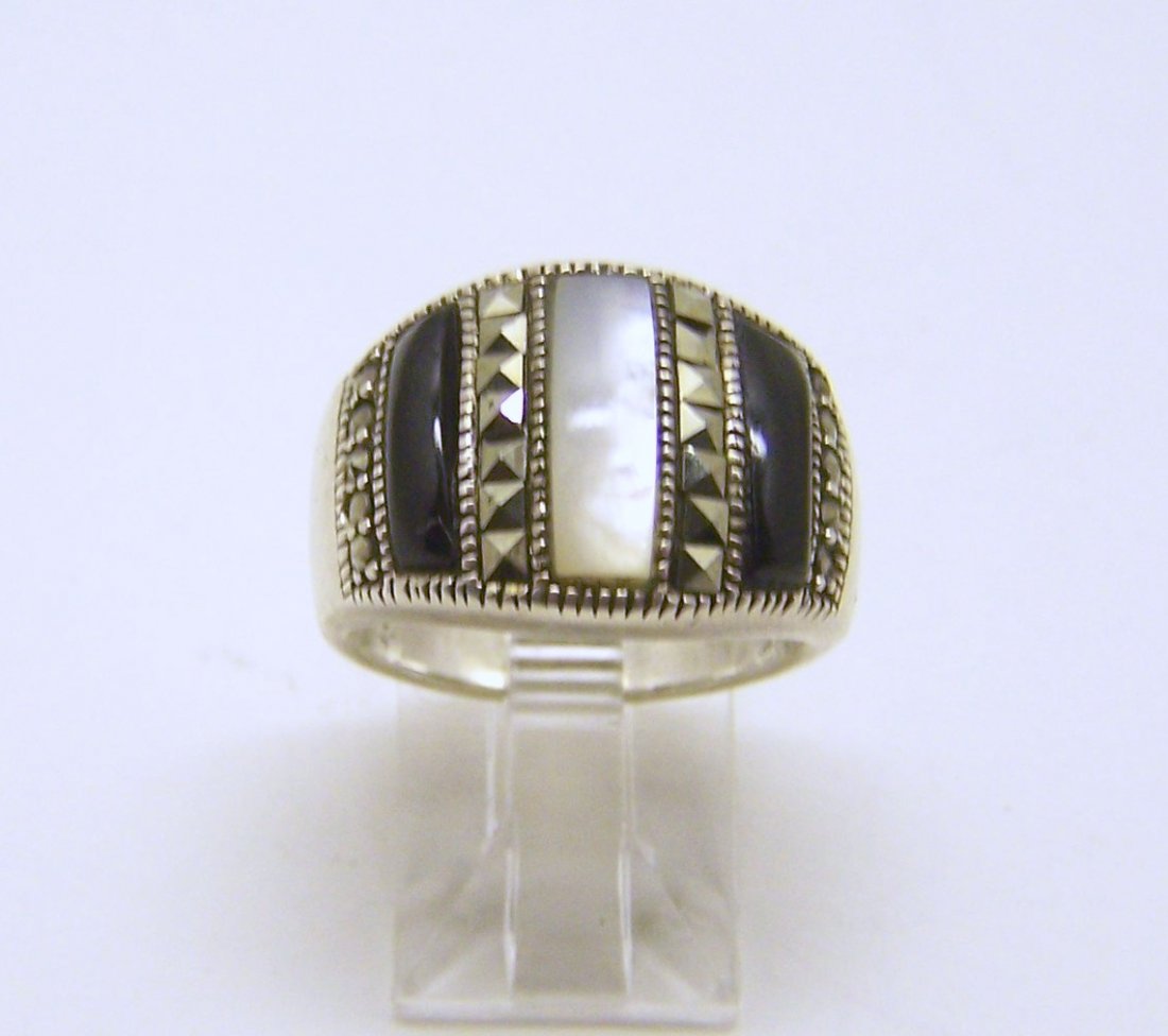 NF sterling silver onyx mother pearl marcasite ring: top of the ring measures 9/16" wide, size 7 1/4, weights 6.5 grams, in good condition