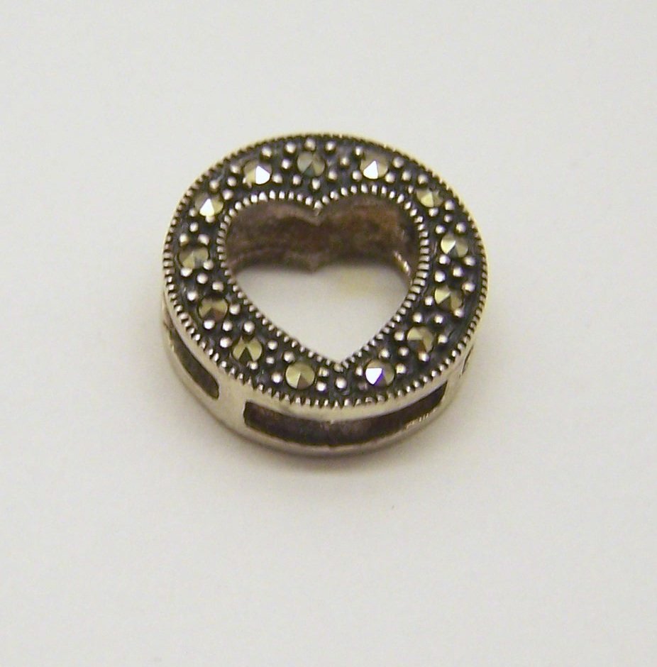 sterling silver marcasite pendant: measures 9/16" in diameter, weights 2.4 grams, in good condition