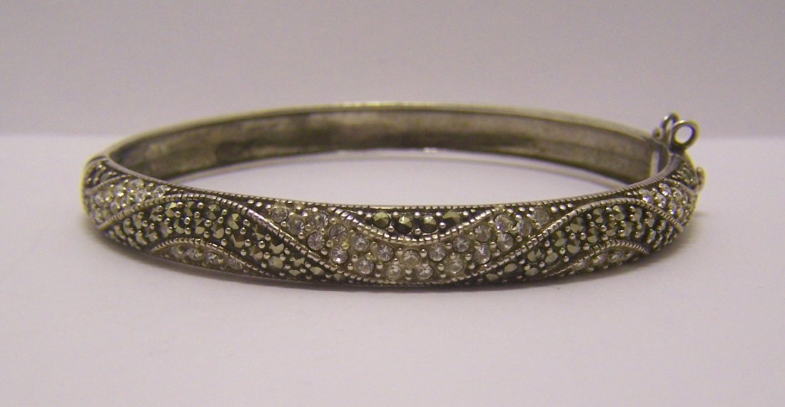 A sterling silver Cz marcasite bangle bracelet: 7 3/16" inside circunference by 5/16" wide, weights 21.1 grams, in good condition
