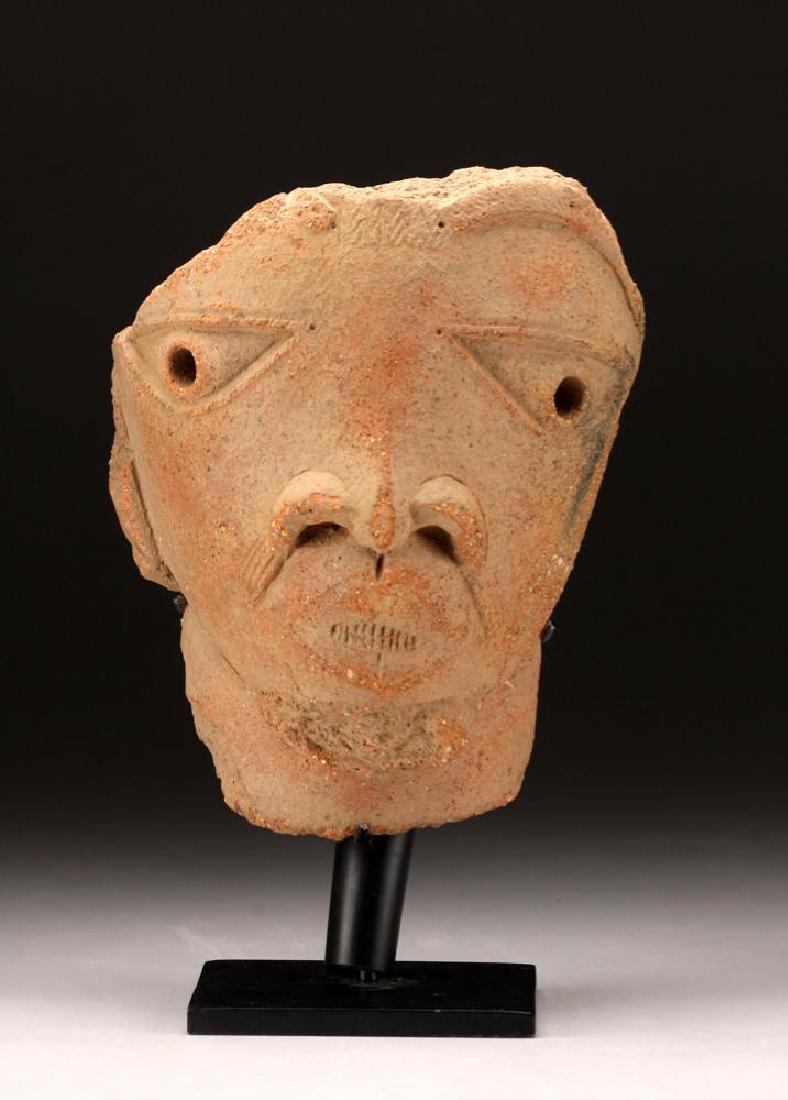 Nigerian Nok Terracotta Sculpted Head: Shard sculpted head on a museum metal stand. Shipping weight: 2 1/2 lbs._ Size: H: 6; overall: 7 1/2 inches.