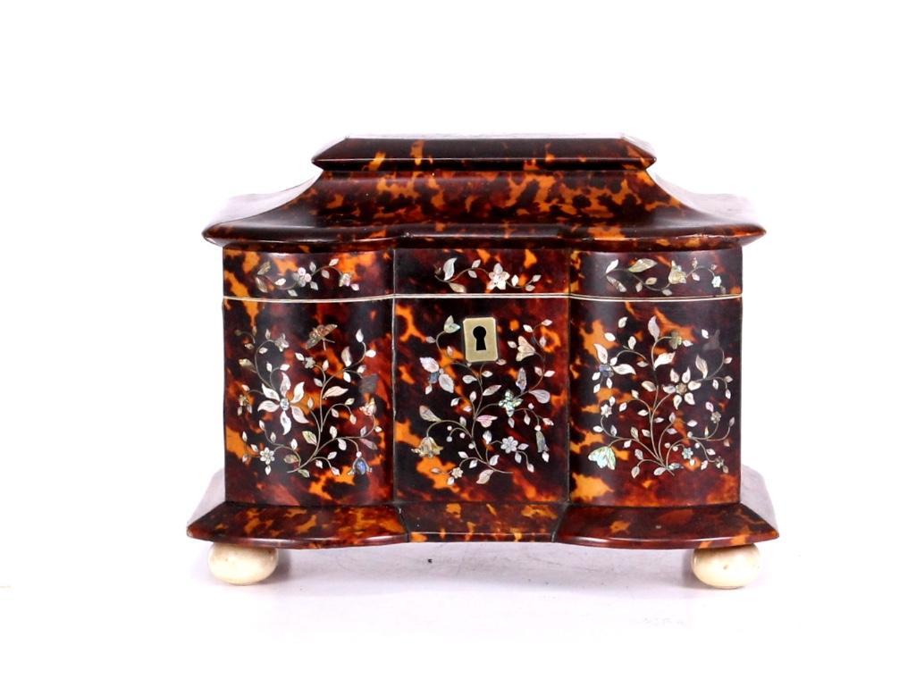 English 19th C. Mother-of-Pearl Inlaid Shell Tea Caddy: A 19th century sarcophagus-form English tea caddy with scalloped front made from shell and inlaid on front and top with mother-of-pearl floral designs. Interior with two lidded compartments. Stands on
