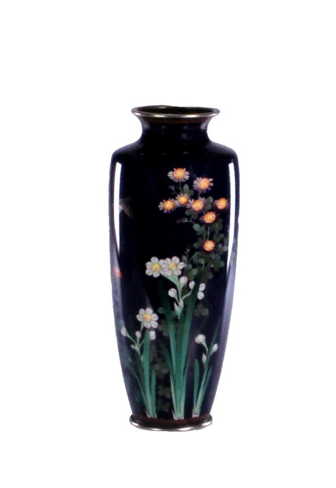 Japanese Meiji Period Cloisonne Vase: A Japanese cloisonne vase depicting various flowers and a bird in flight. Height: 9 3/8 inches. Weight: 1 lb. Condition: Some scraping and chipping of enamel.
