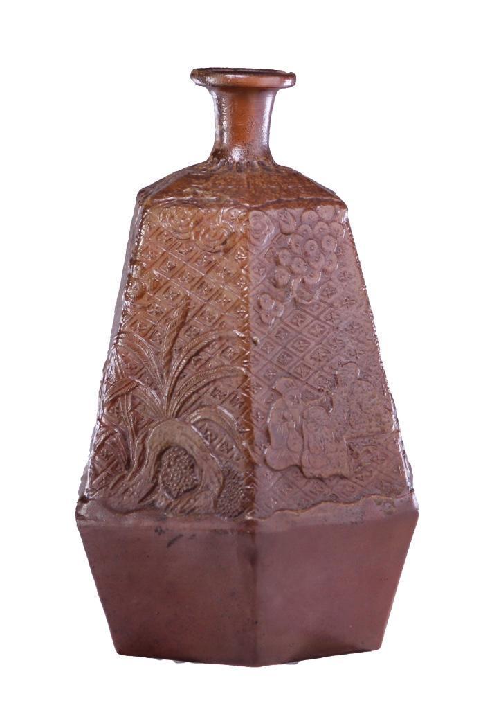 Japanese Edo Period Bizen Ware Tokkuri: A Bizen tokkuri produced circa 1775. Its six faces are decorated in a wrapping relief of a garden scene. Height: 9 inches. Weight: 2 lbs.