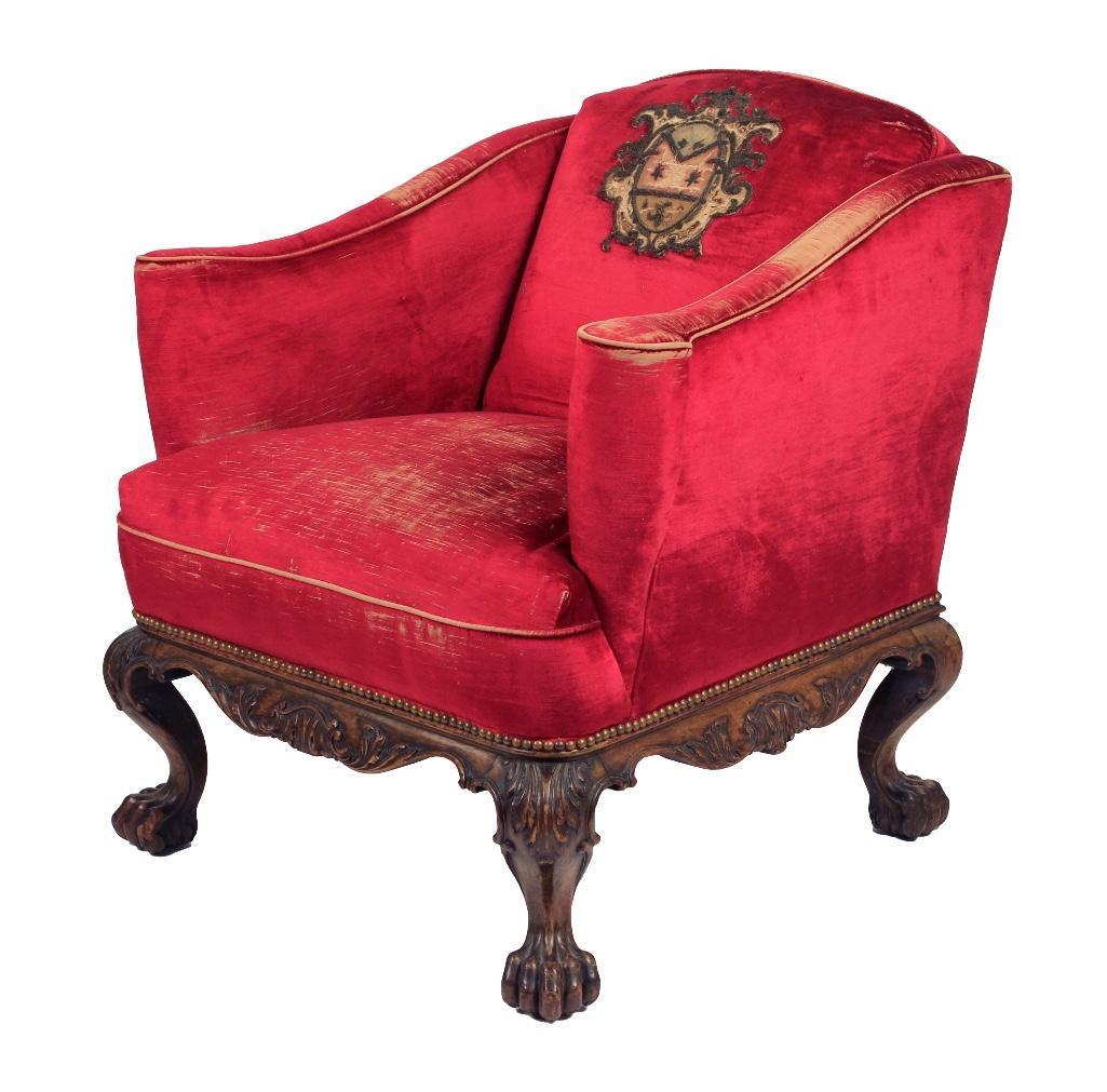 Continental Red Upholstered Bergere: The bergere comprised of a square carved walnut frame with scrolled apron and claw feet. The red upholstery with older applied crest. Height: 32 1/2 inches. Condition: Upholstery worn