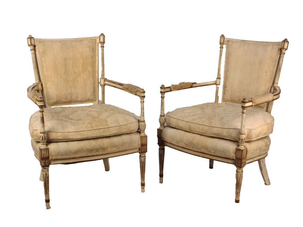 Pair of French Louis XVI Style Fanteuils: The white painted Louis XVI style fanteuils with fabric seat, armrests and back. Height: 37 inches. Condition: Fabric worn and stained. Front leg end restored on one. 