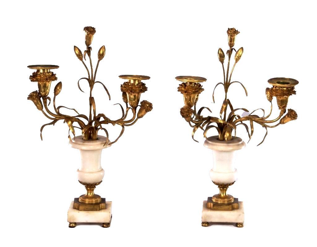 Pair of Ormolu & Alabaster Candelabra: Matched ormolu two-armed candelabra with alabaster stem and base. Sconces styled as blooming flowers with surrounding flowers and flower buds, with cluster of gilt leaves at connector. Height: 15 inch