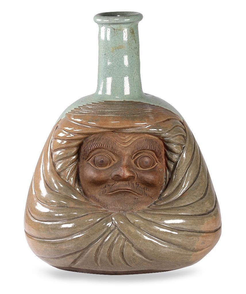 Japanese Meiji Period Daruma Face Vase: Green and brownÎ¾glazed vase with carved DarumaÎ¾face unglazed. Small tablet on reverse possible mark. Height: 11 1/2 inches. Shipping weight: 4 3/4 lbs.Î¾ Condition: Mark around neck just under
