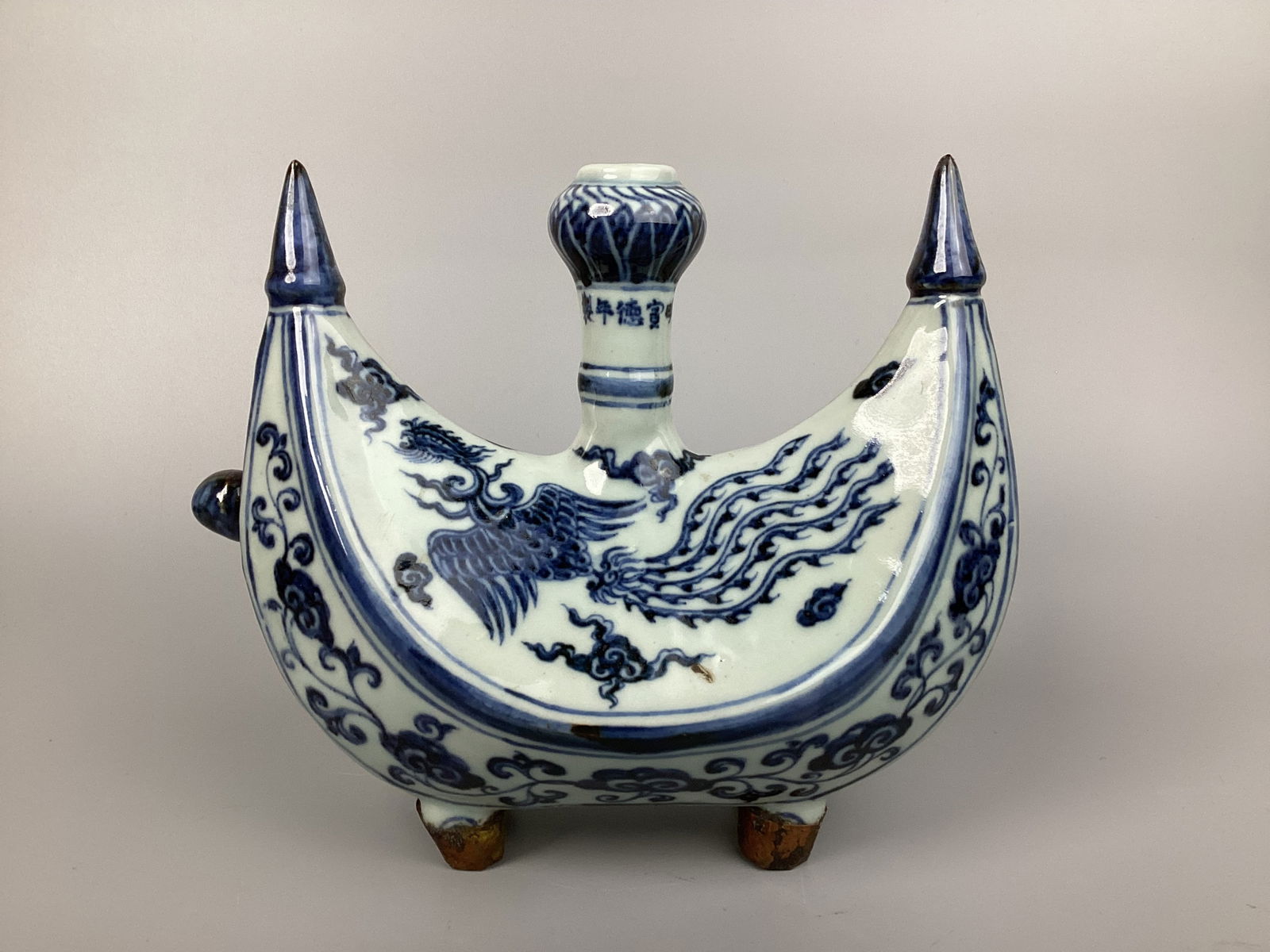 Chinese 15C Xuande A blue and white 'Figural' crescent-shaped wine flask: Chinese 15C Xuande 明宣德 青花枝纏花卉紋酒壺 A blue and white 'Figural' crescent-shaped wine flask Size: H: 5" W: 7.1" L:8.7"Con