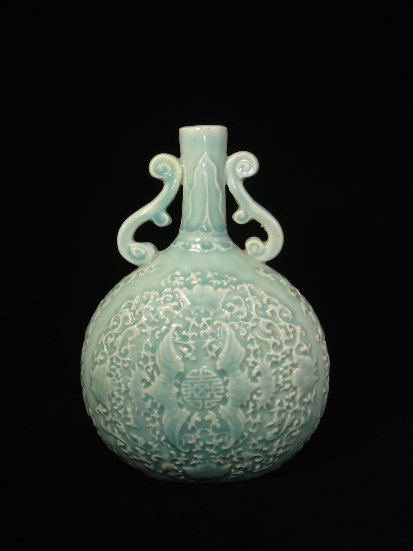 Chinese celadon moon flaskwith ears: Chinese celadon moon flaskwith ears, decorated with engravings of roundel pattern in the middle surrounded by bats and foliage, character mark on base. Size: 9 1/2" Ht. 6 3/4" W. Condition: Good condi