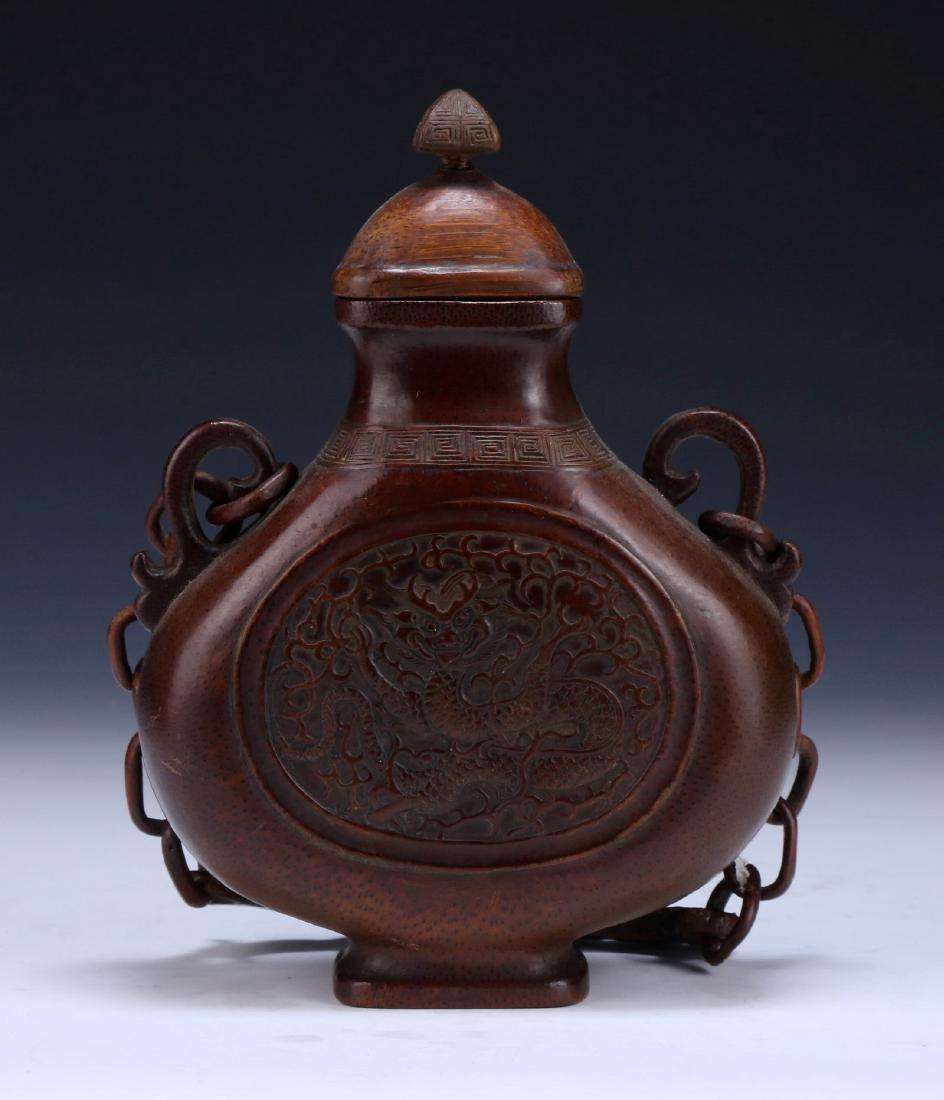 A CHINESE ANTIQUE CARVED BAMBOO HANGING VASE: 竹根雕龍紋掛瓶A Chinese Antique Carved Bamboo Hanging Vase: Qing Dynasty, Late 19Th Century, The Hollowed Vessel Is Carved Of Flat Compressed Globular Form, W
