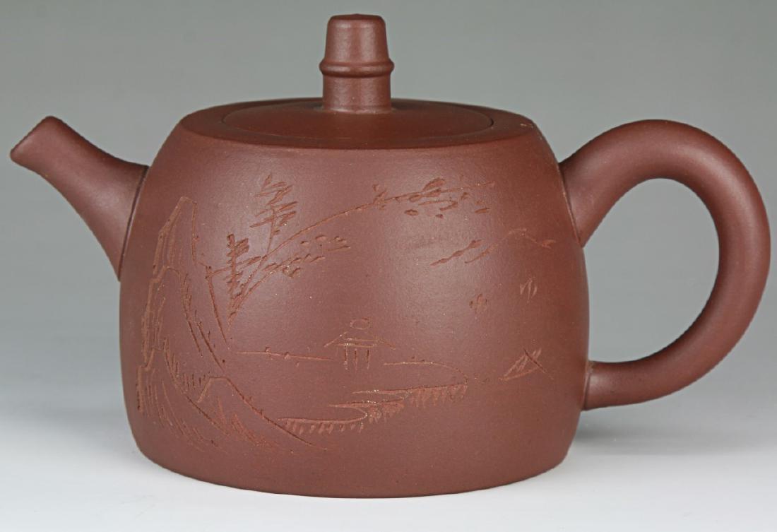A CHINESE YIXING ZISHA TEAPOT WITH COVER: A Chinese Yixing Zisha Teapot With Cover: One Side inscribed With A Figure Amid Rockery, Sign On The Base And Under The Handle; Size: L: 6" (15.24cm)