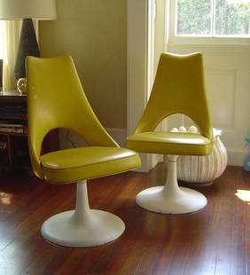 Pair of Lounge Chairs: Designer: Hagins Mortiner Pair of lounge chairs in the style of Saarinen. Yellow vinyl with white enamel bases. Some wear on bases consistent with age. 18" w x 24" d x 33 h overall; 17" seat height.